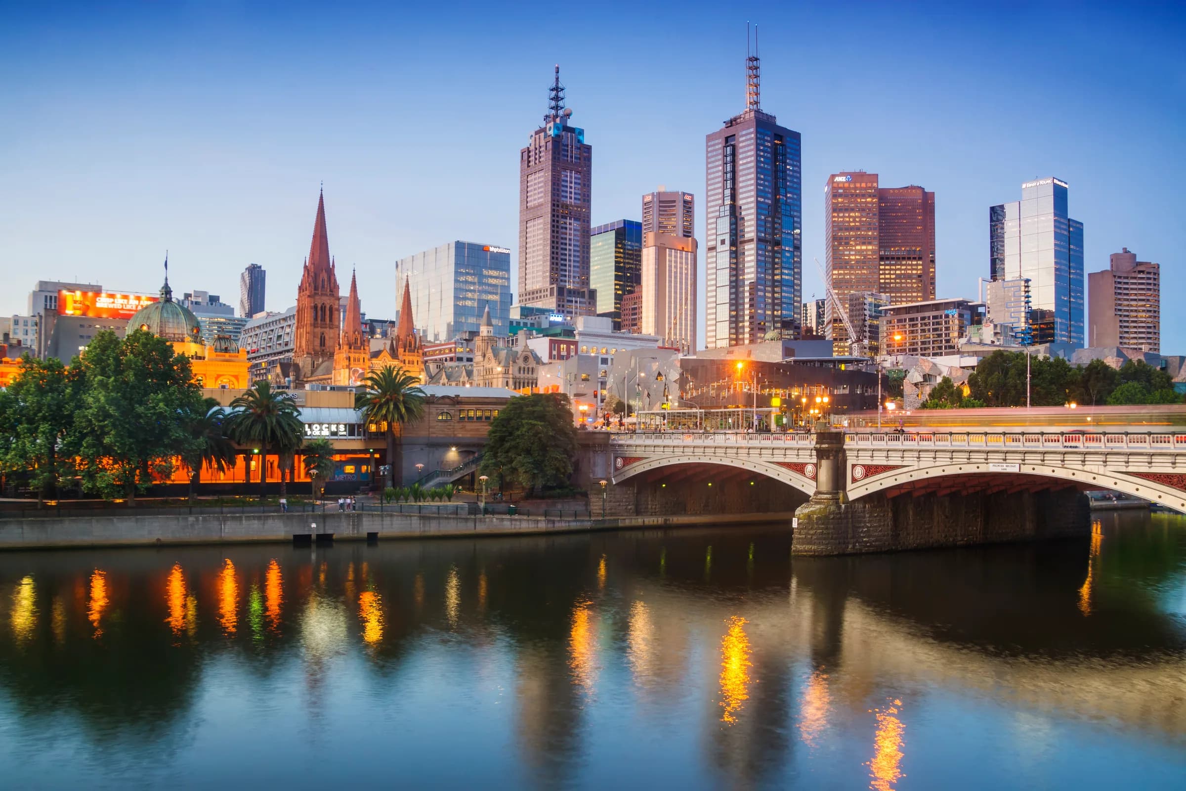 City skyline and bridge reflected in the water at dusk